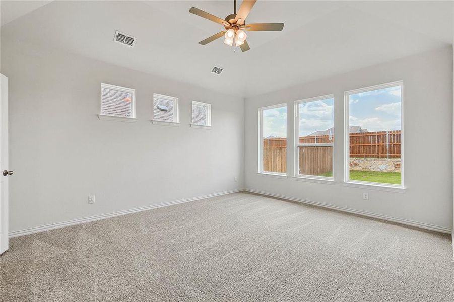 Unfurnished room with plenty of natural light, ceiling fan, and light colored carpet