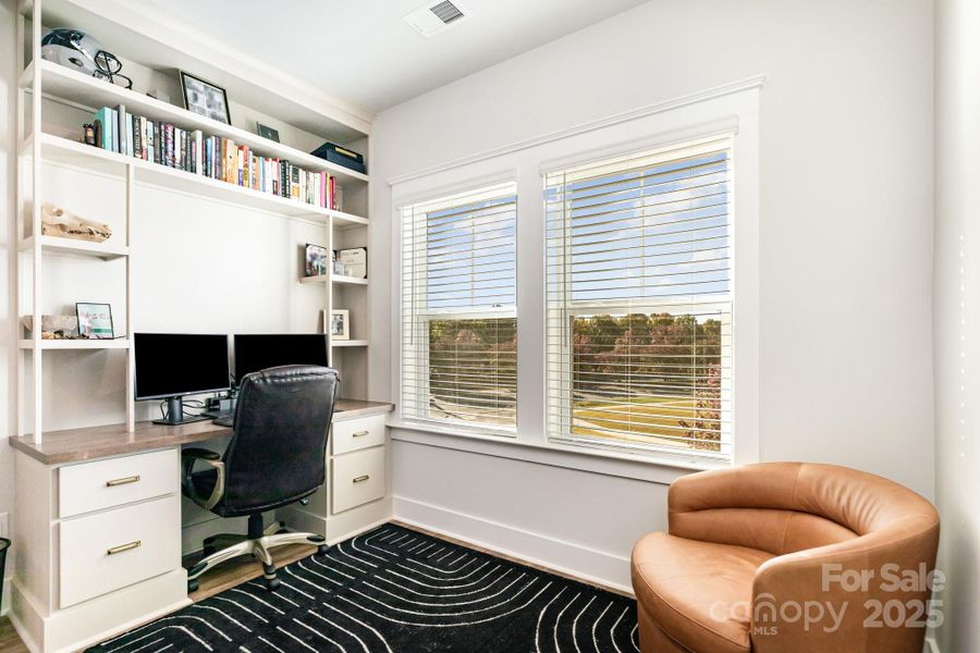 Custom floor to ceiling built in desk makes great use of landing for a sunny office space and household command center.