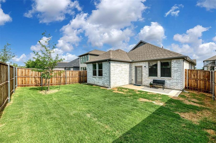 Back of property with brick siding, a shingled roof, and a fenced backyard Back of property with brick siding, a shingled roof, and a fenced backyard