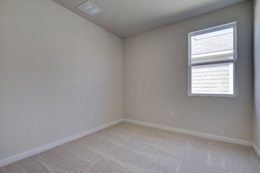 A room with a window and a carpet.