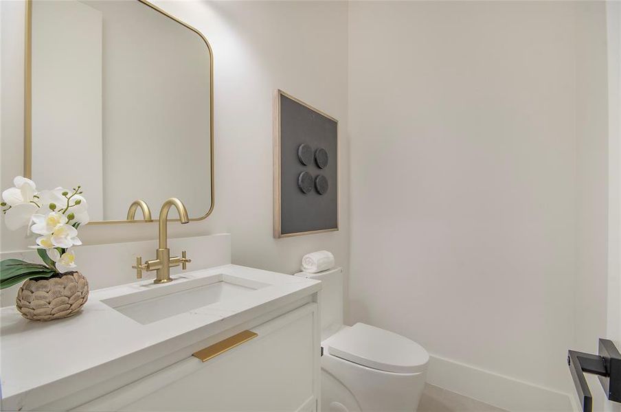 Half bath featuring vanity and toilet Half bath featuring vanity and toilet