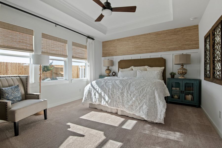 Primary suite with tray ceiling and decorative feature wall Primary suite with tray ceiling and decorative feature wall