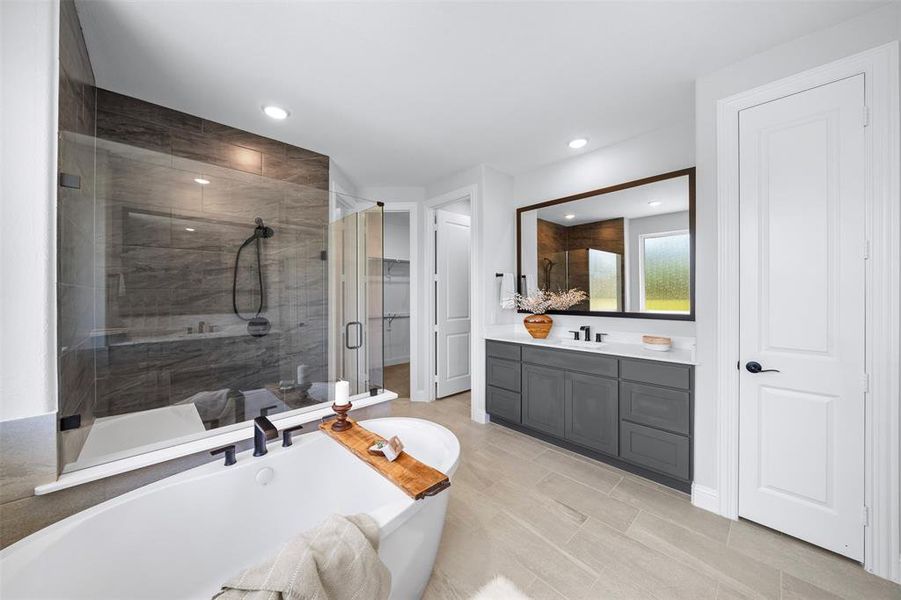 Full bath featuring a soaking tub, a shower stall, vanity, and recessed lighting