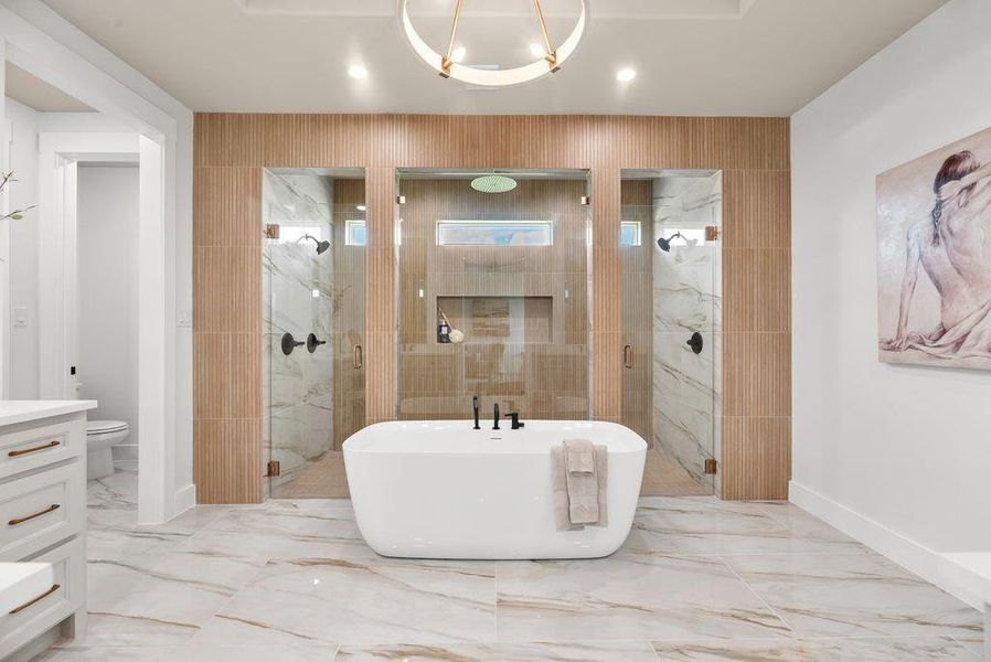 Bathroom with a marble finish shower, a soaking tub, vanity, and light marble finish flooring Bathroom with a marble finish shower, a soaking tub, vanity, and light marble finish flooring
