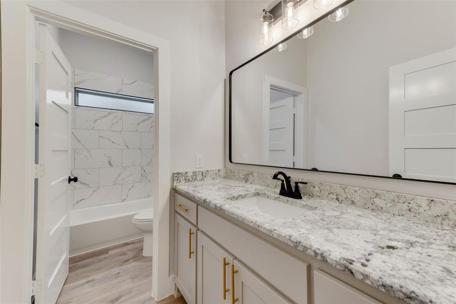 Bathroom featuring vanity, light wood-type flooring, and bathtub / shower combination Bathroom featuring vanity, light wood-type flooring, and bathtub / shower combination