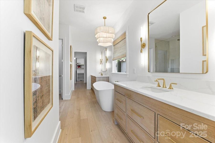 Spa-inspired ensuite bathroom featuring a freestanding soaking tub, oversized walk in shower, dual vanities, and separate water closet. Spa-inspired ensuite bathroom featuring a freestanding soaking tub, oversized walk in shower, dual vanities, and separate water closet.