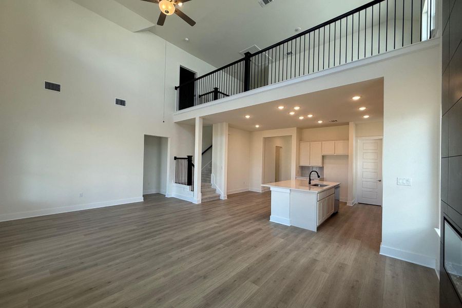 An open-concept living space with soaring ceilings and a modern kitchen island creates a harmonious flow. An open-concept living space with soaring ceilings and a modern kitchen island creates a harmonious flow.