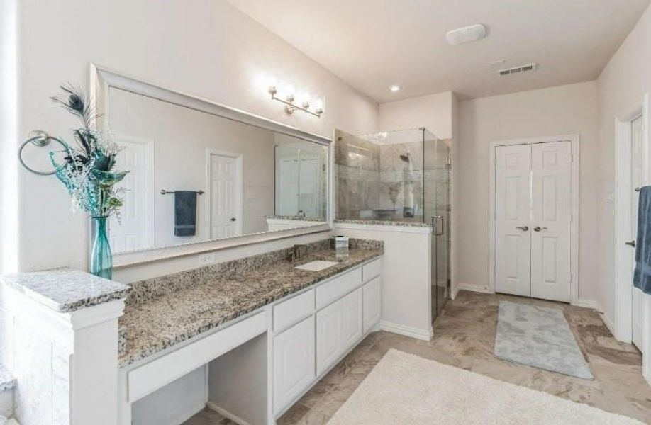 Bathroom with tile patterned flooring, an enclosed shower, and vanity