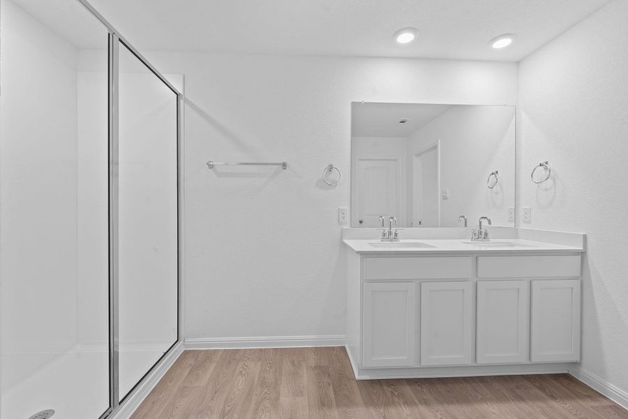 Full bathroom with light wood-type flooring, double vanity, and a shower stall Full bathroom with light wood-type flooring, double vanity, and a shower stall