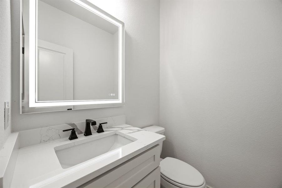 Half bathroom featuring toilet and vanity Half bathroom featuring toilet and vanity