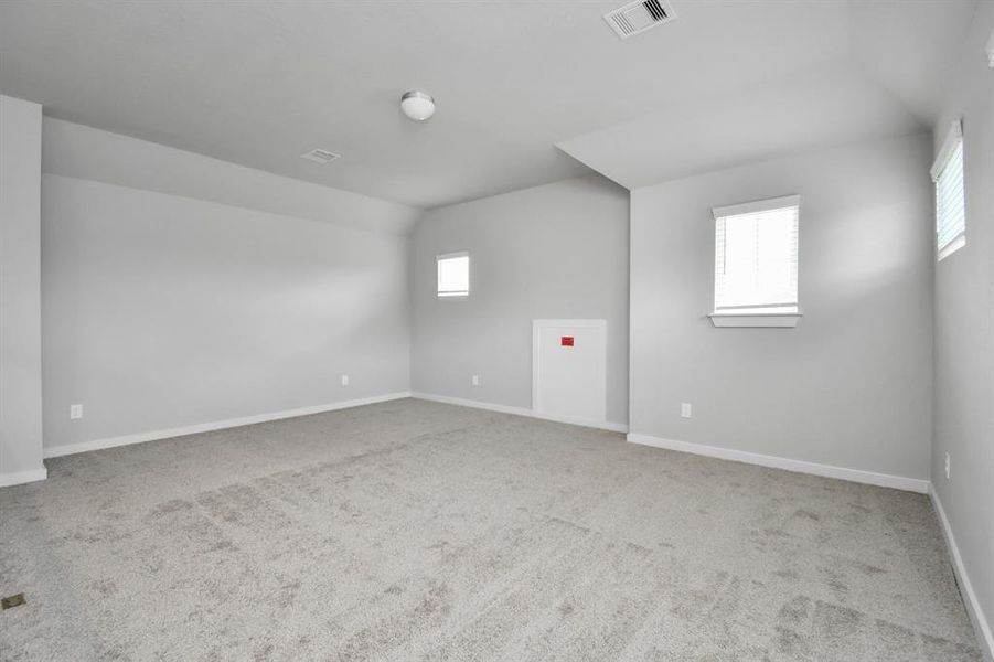 Come upstairs and enjoy a day of leisure in this fabulous game room! This is the perfect hangout spot or adult game room! Features plush carpet, high ceilings, custom paint and windows for plenty of natural light.