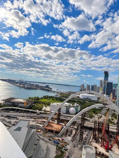 Elevated high-rise perspective featuring panoramic water, bridge, and cityscape scenery