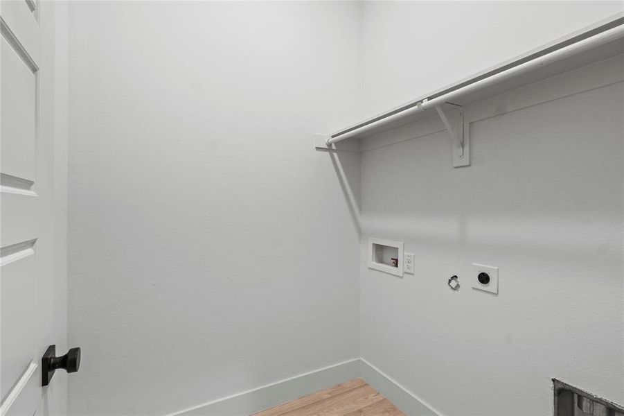 Clothes washing area featuring hardwood / wood-style flooring, washer hookup, hookup for a gas dryer, and electric dryer hookup