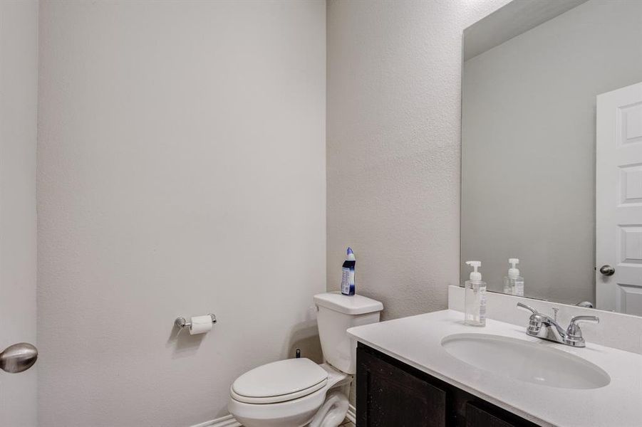 Half bath featuring a textured wall and vanity Half bath featuring a textured wall and vanity