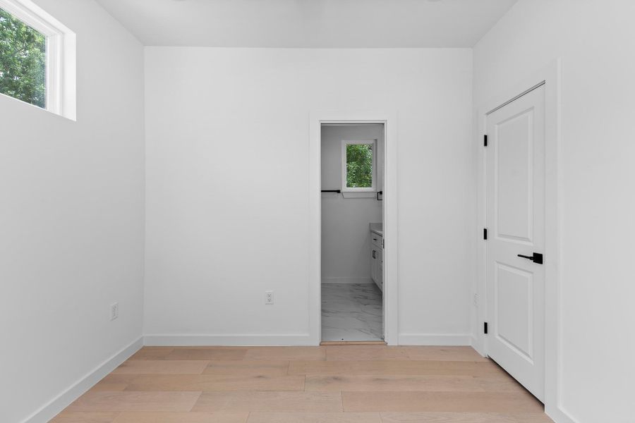 Blonde hardwood flooring complements the bright walls in this versatile interior space.