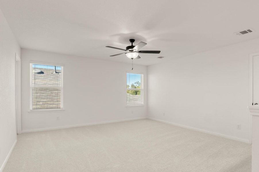 Unfurnished room with light colored carpet and a ceiling fan Unfurnished room with light colored carpet and a ceiling fan
