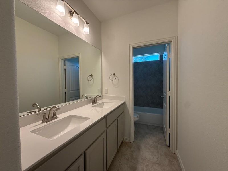 Full bathroom featuring double vanity and a bath