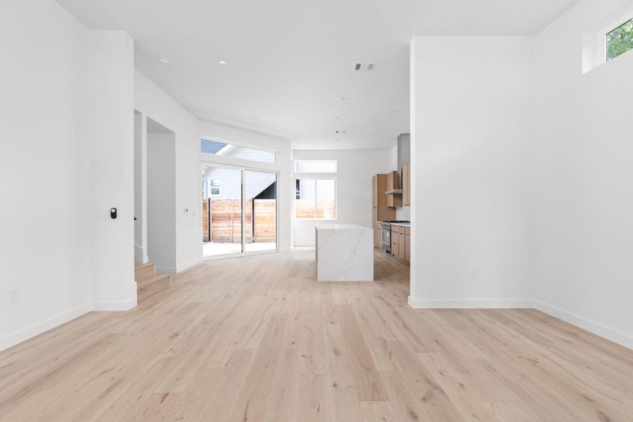 Unfurnished living room featuring light wood-type flooring and baseboards Unfurnished living room featuring light wood-type flooring and baseboards