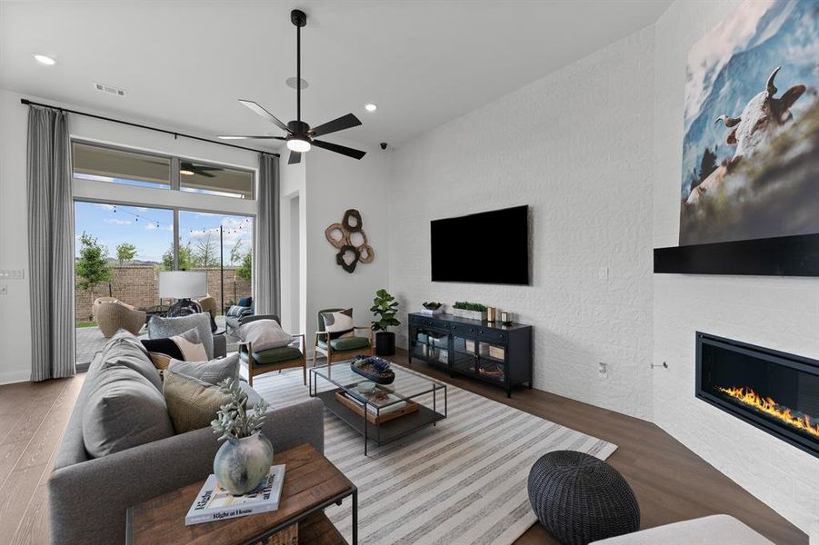 Living room featuring wood finished floors, a fireplace, a ceiling fan, and recessed lighting Living room featuring wood finished floors, a fireplace, a ceiling fan, and recessed lighting