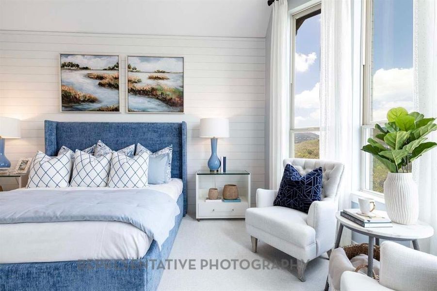 Carpeted bedroom featuring multiple windows and wood walls