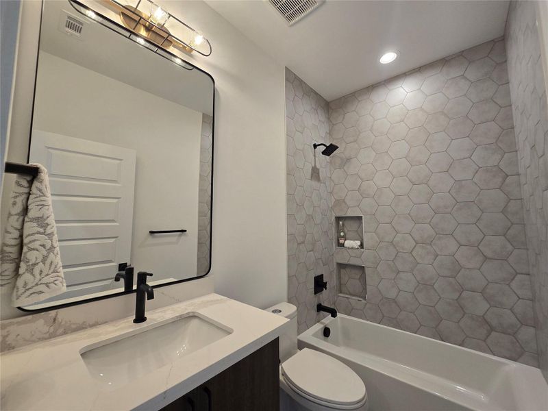 Secondary bath for the other bedrooms. Built in soap niches in the tub area.