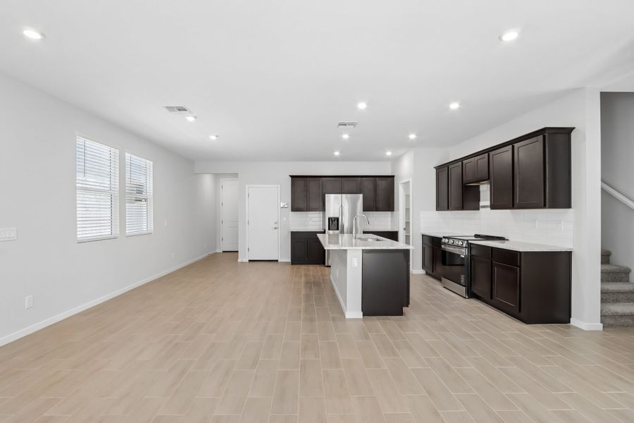 A large kitchen with black cabinets.