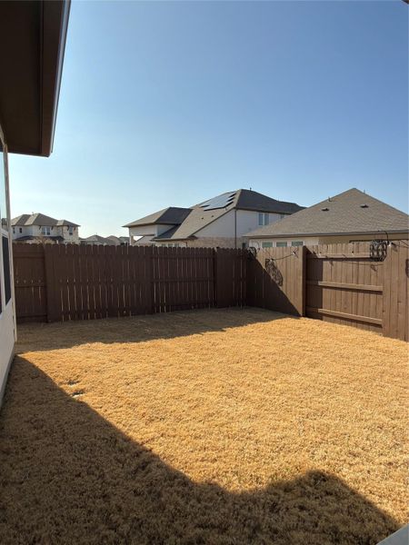 Spacious backyard with a wood privacy fence, expansive grass area, and substantial side yard