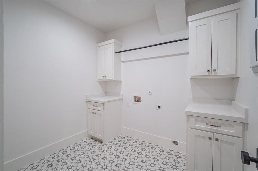 Laundry area with electric dryer hookup, hookup for a washing machine, and cabinets