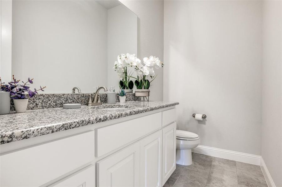 Bathroom with tile patterned floors, vanity, and toilet