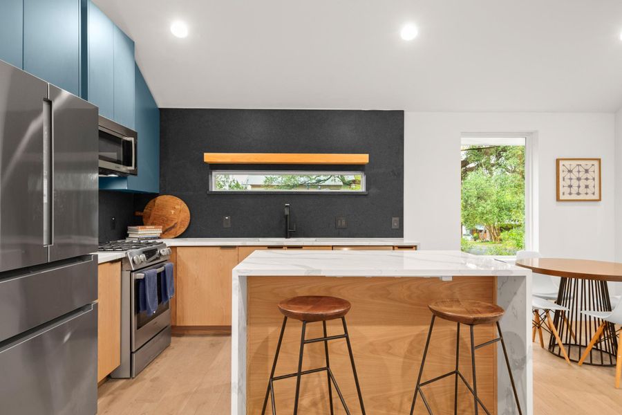 Kitchen featuring appliances with stainless steel finishes, light stone countertops, healthy amount of natural light, and recessed lighting