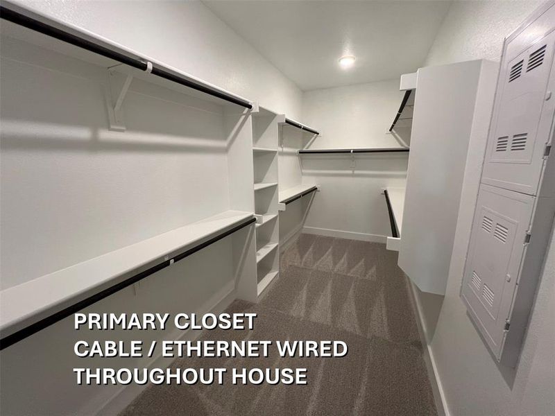 Spacious walk-in closet featuring built-in shelving, hanging rods, recessed lighting, and soft carpeting Spacious walk-in closet featuring built-in shelving, hanging rods, recessed lighting, and soft carpeting