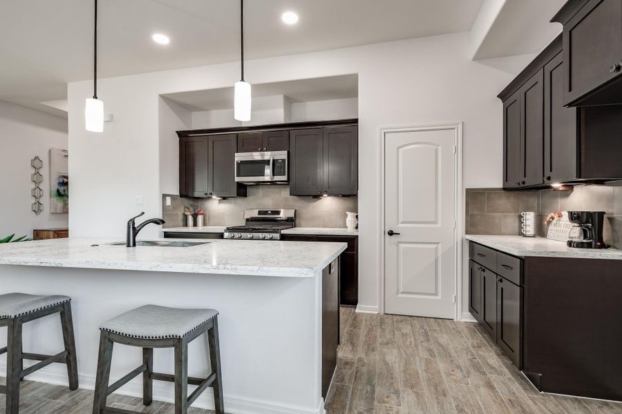 Stylish kitchen overlooking dining room for easy hosting.abundant cabinet storage.