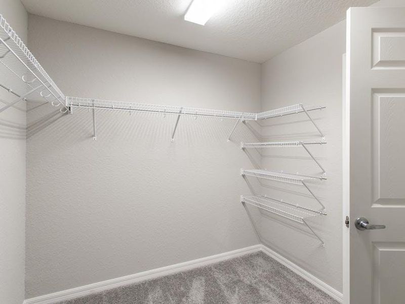 Walk-in wardrobe in your owner`s suite - Photo showcases a home with similar finishes. Colors and design options in actual home for sale may differ.