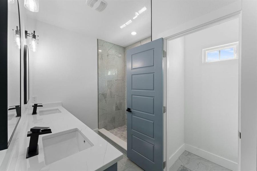 Bathroom featuring vanity and tiled shower