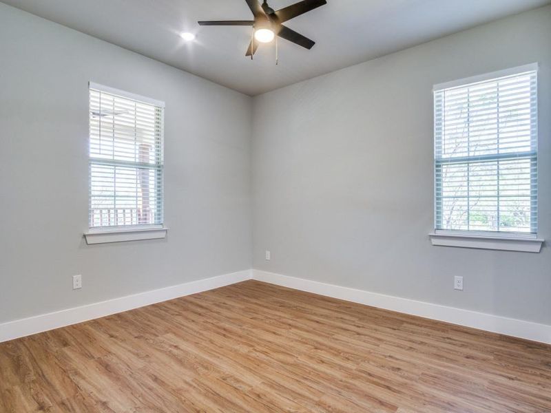 Empty room with ceiling fan and light wood-type flooring