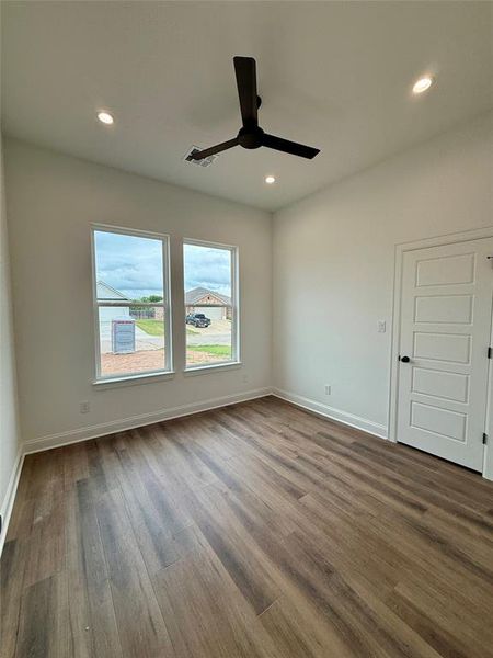 Interior room featuring wood-finish flooring and a contemporary black ceiling fan
