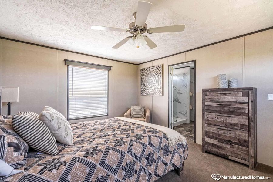 The tranquil bedroom offers soft carpeting and a ceiling fan, creating a comfortable haven.