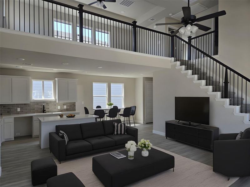 Living room featuring a high ceiling, a ceiling fan, light wood-style flooring, and recessed lighting