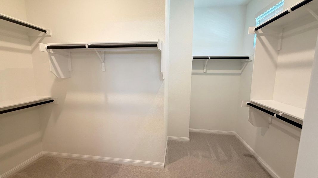 Ample shelving and hanging rods provide generous storage in this well-appointed closet. Ample shelving and hanging rods provide generous storage in this well-appointed closet.