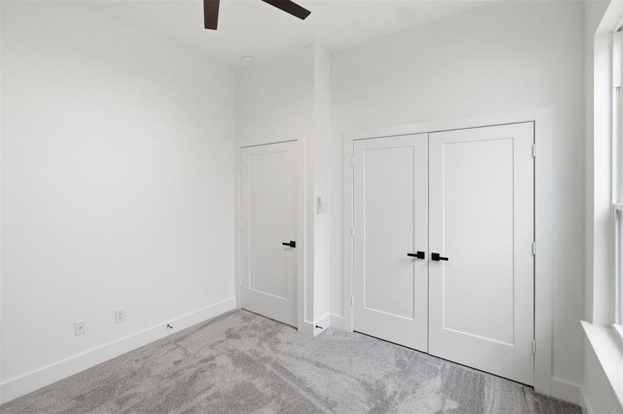 Unfurnished bedroom featuring carpet flooring, ceiling fan, and a closet