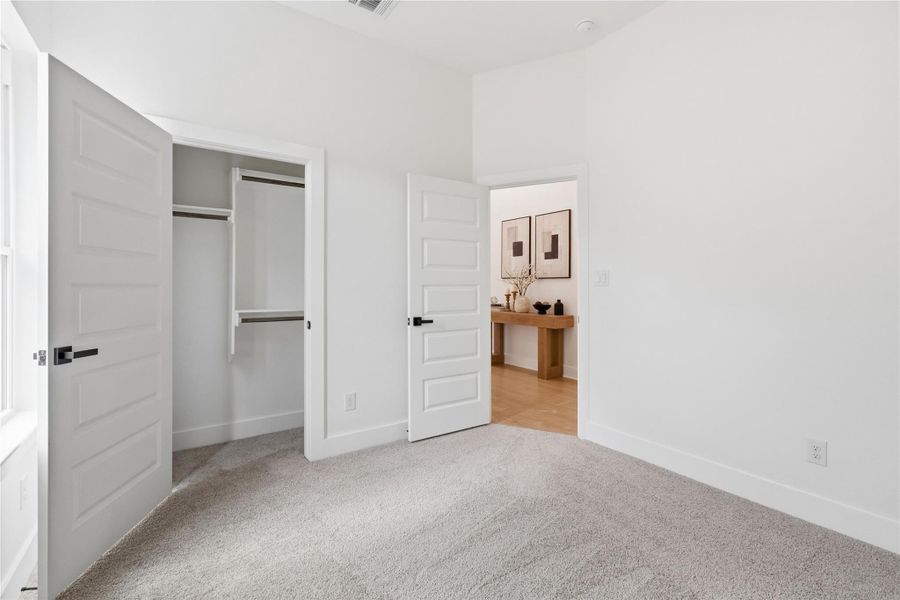 Unfurnished bedroom featuring light colored carpet and a closet