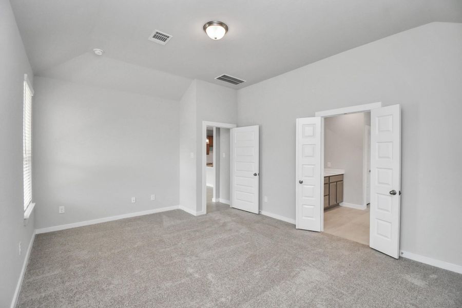 Come and unwind after a long day in this magnificent primary suite! This spacious room features plush carpet, warm paint, high ceilings and large windows with privacy blinds. Sample photo of completed home with similar floor plan. Actual colors and selections may vary.