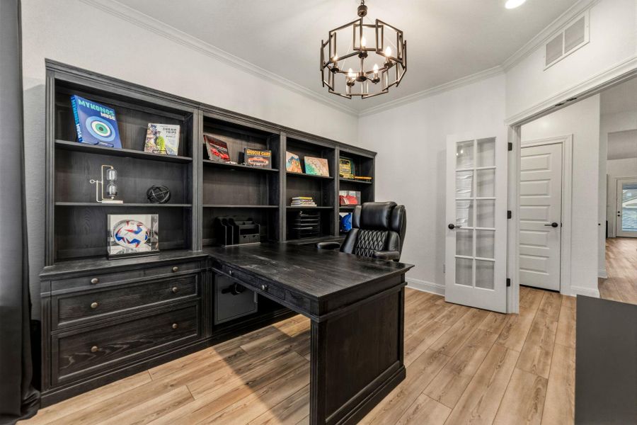 Featuring crown molding, french doors, recessed and chandelier lighting.