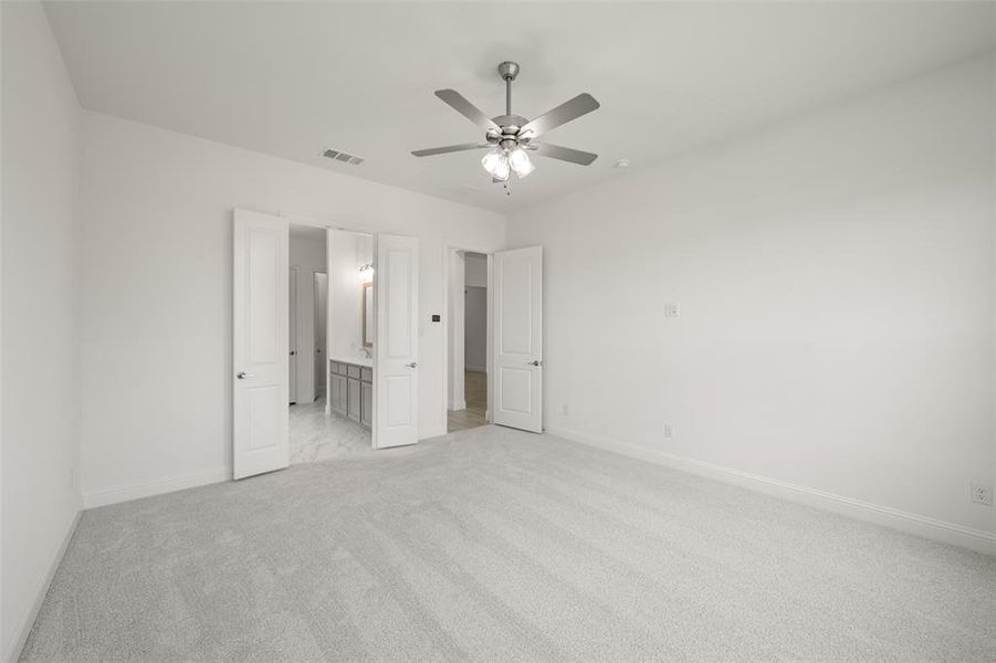 Unfurnished bedroom featuring light carpet, ensuite bath, and ceiling fan Unfurnished bedroom featuring light carpet, ensuite bath, and ceiling fan