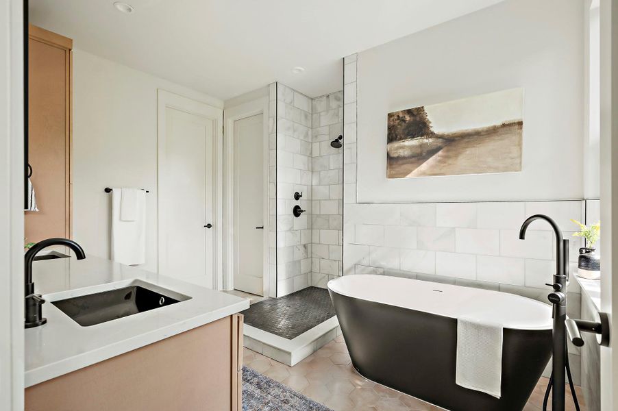 Full bathroom with tiled shower, a freestanding bath, vanity, tile walls, and tile patterned flooring