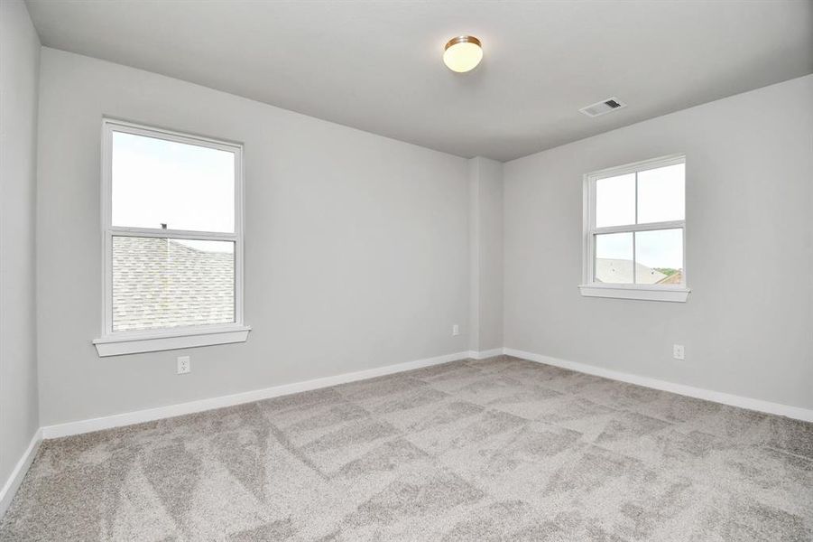 Generously sized secondary bedrooms, complete with spacious closets and soft, inviting carpeting. Enjoy abundant natural light streaming in through the large windows. Sample photo of completed home with similar floor plan. Actual colors and selections may vary.