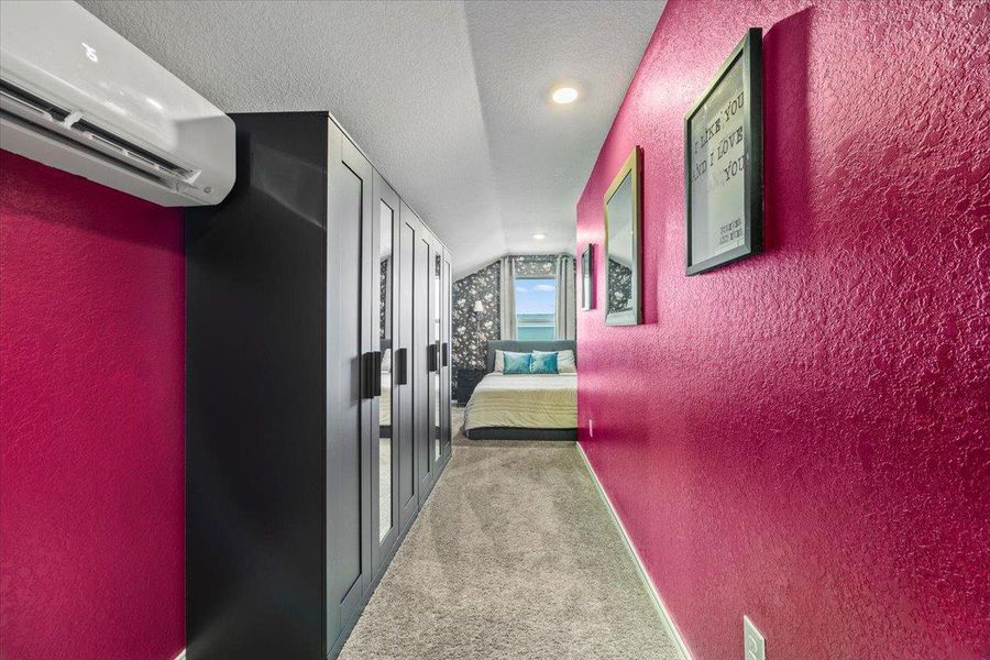 Hall with a textured wall, light carpet, and recessed lighting Hall with a textured wall, light carpet, and recessed lighting