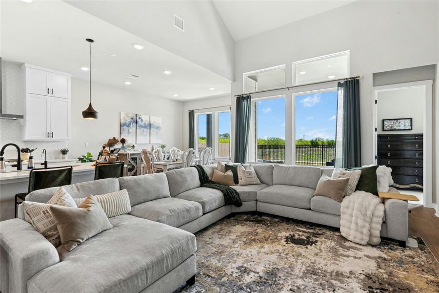 Open Living room with view of the backyard and high ceilings with recessed lighting.