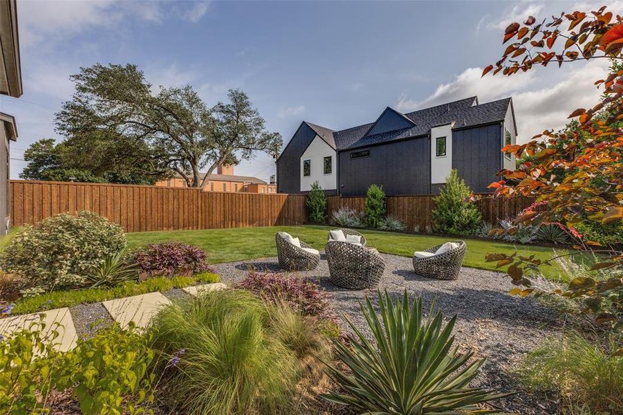Expansive backyard featuring a lush lawn, gravel patio, and vibrant landscaping Expansive backyard featuring a lush lawn, gravel patio, and vibrant landscaping