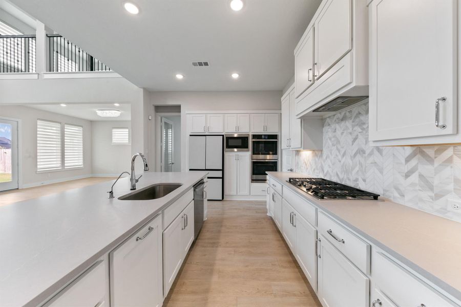 Chef-inspired kitchen featuring sleek countertops, modern cabinetry, and stainless steel appliances, all highlighted by abundant natural light. The spacious layout and ample prep space make it ideal for both cooking and entertaining.